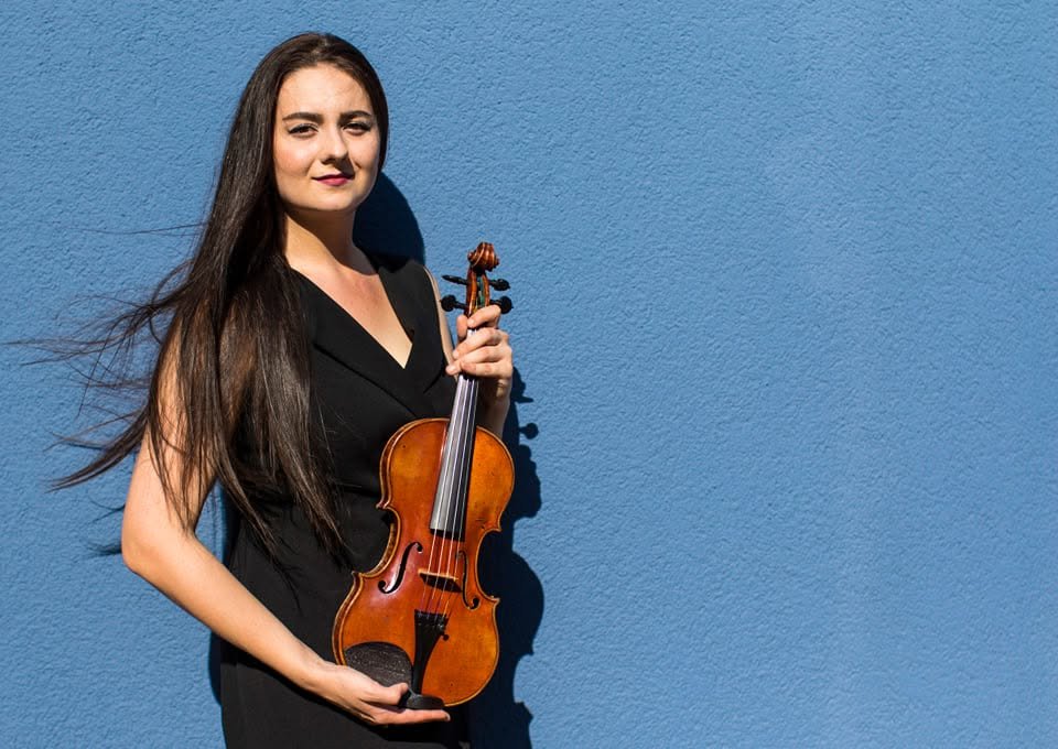 Violinist portrait against a blue wall in Berlin