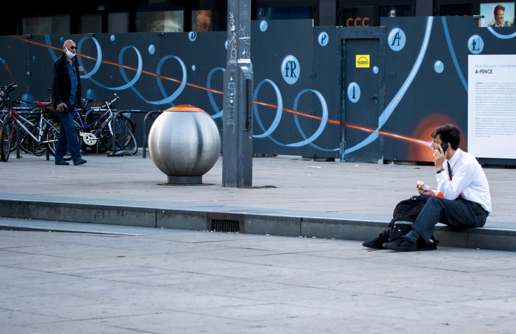 A street photo of a man shooting lazer from his eyes in Berlin Alexanderplatz