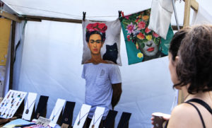 A man stand with a pillow if frida kahlo that create an illusion