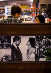 A couple next to a poster that looks like the couple when they are younger