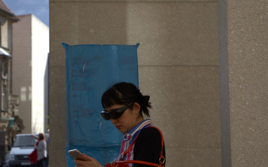 A woman with special sunglasses holding mobile phone in Museum insel Berlin